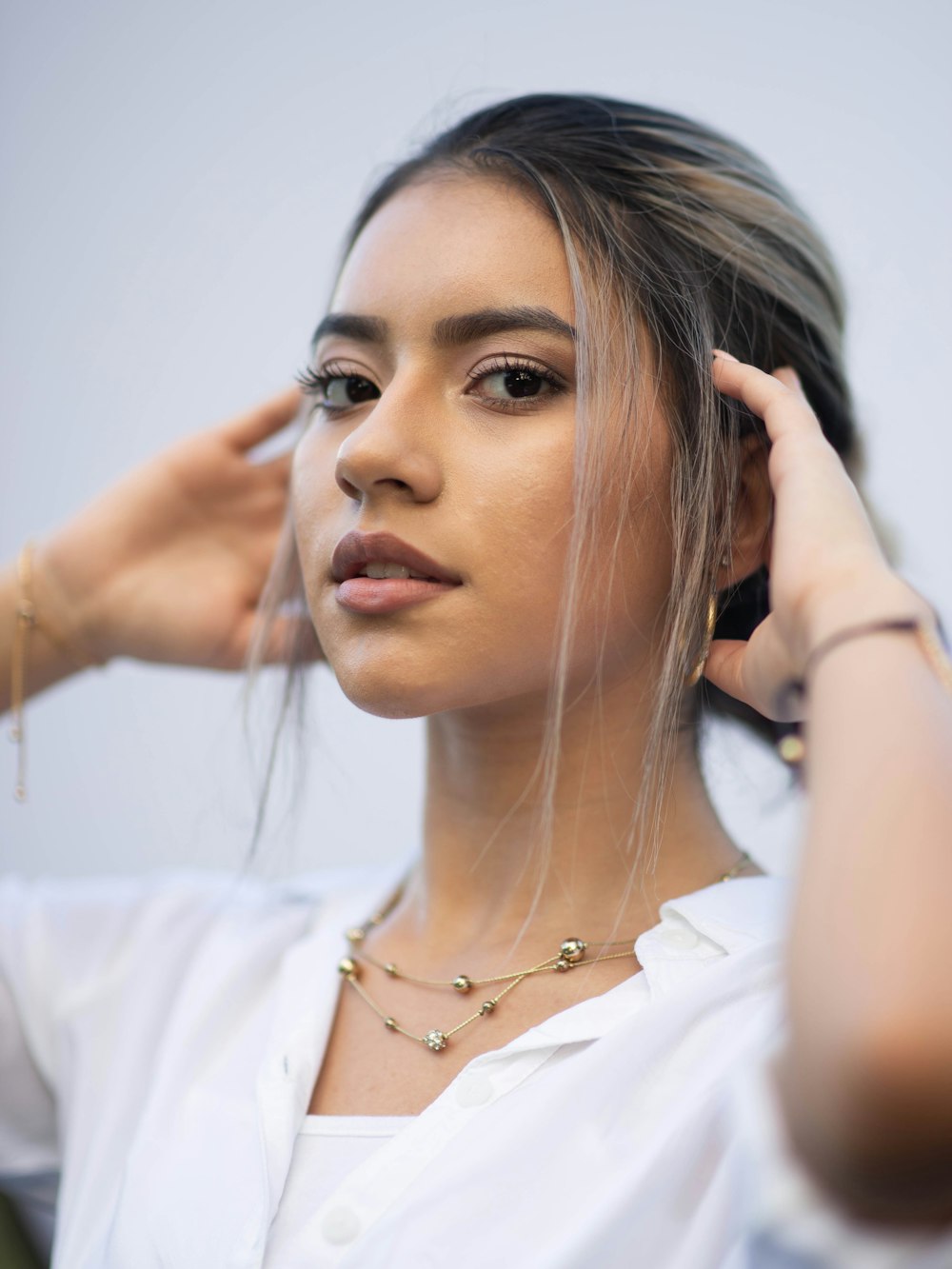 woman in white shirt wearing silver necklace