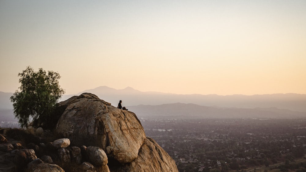 person standing on rock formation near body of water during daytime