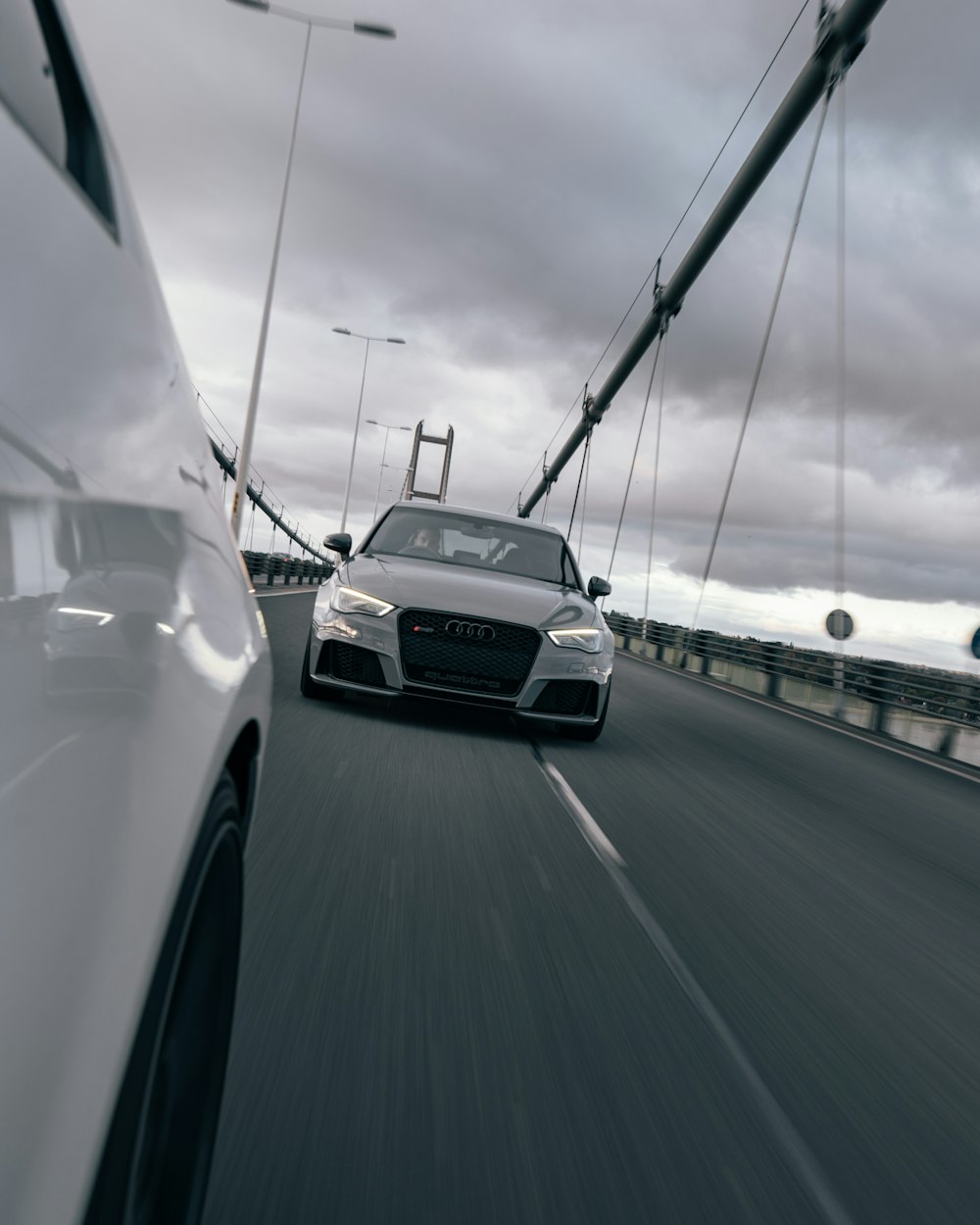 a white car driving down a highway next to a white car