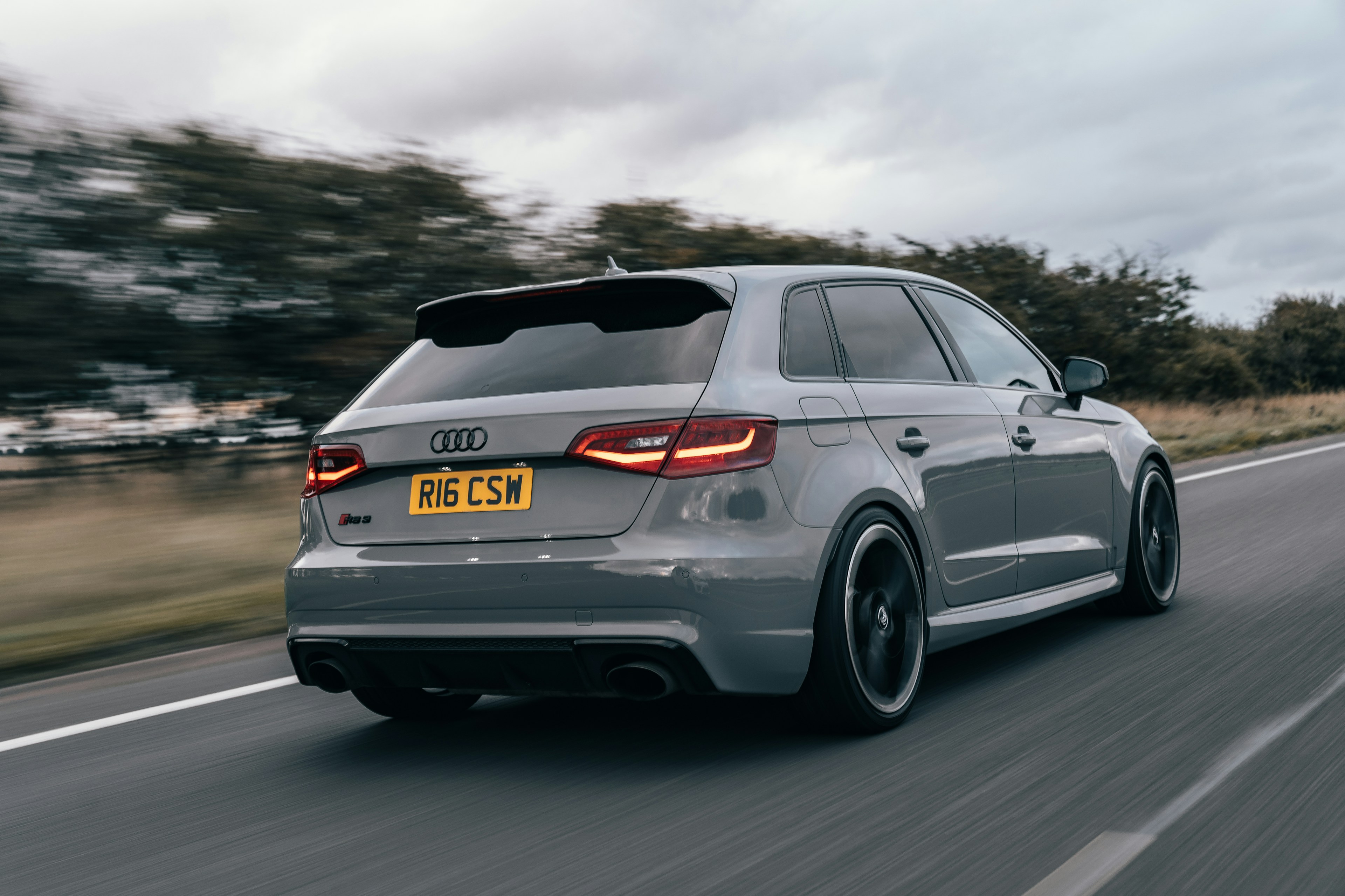 Gray BMW M3 driving on a road