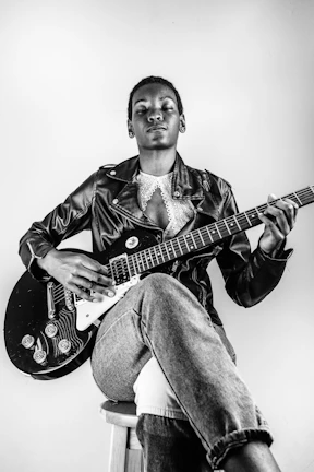 man in black leather jacket playing electric guitar