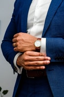 man in blue suit jacket wearing gold round analog watch