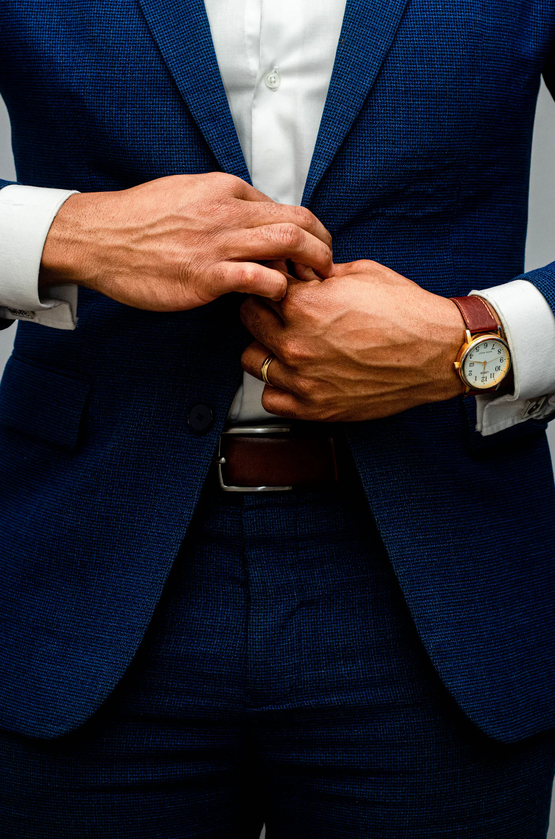 Homme boutonnant sa veste de costume bleu marine sur une chemise blanche