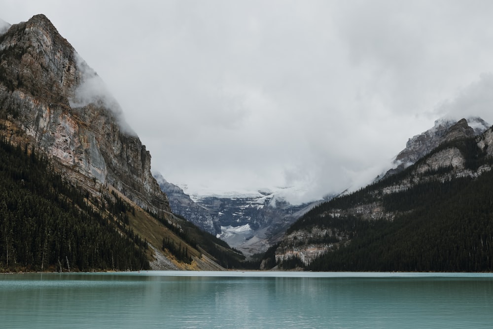 Lac vert près de la montagne sous le ciel blanc pendant la journée