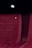 A red upholstered theater seat is prominently featured with the number three embossed on its backrest. The background is dimly lit, suggesting a cinema or theater environment.