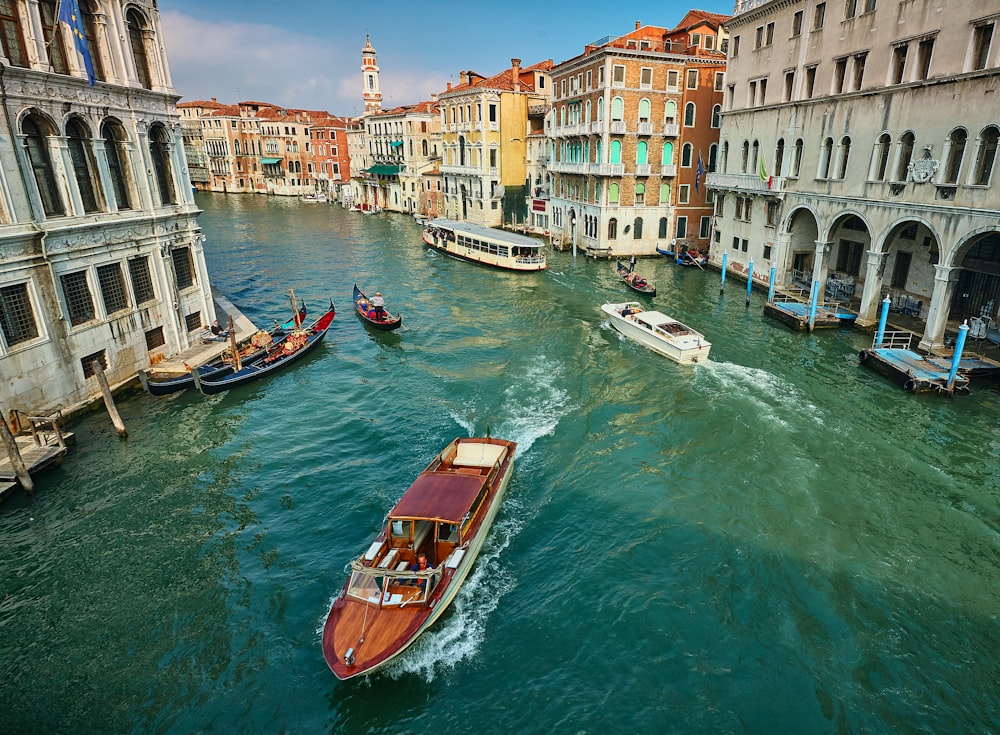 brown boat on river near buildings during daytime