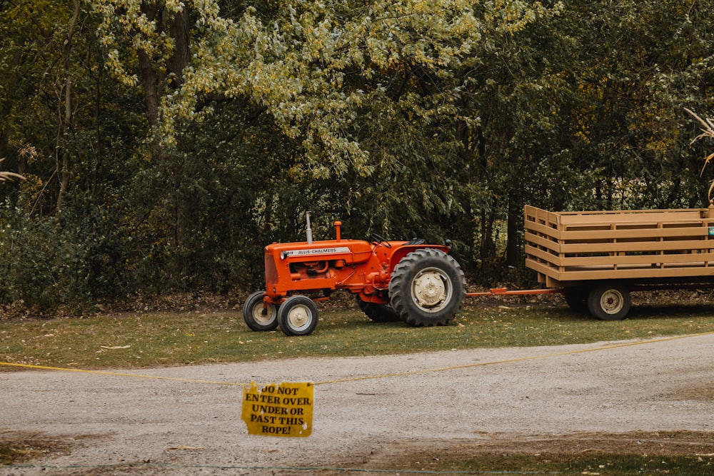 blue tractor on green grass field near green trees during daytime