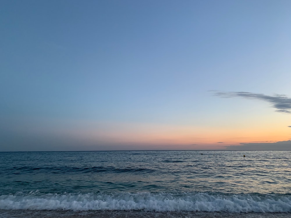 ocean waves crashing on shore during sunset