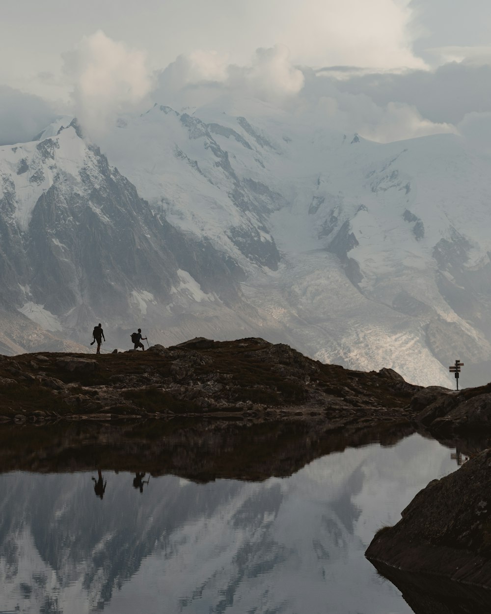 person standing on brown rock formation near lake during daytime