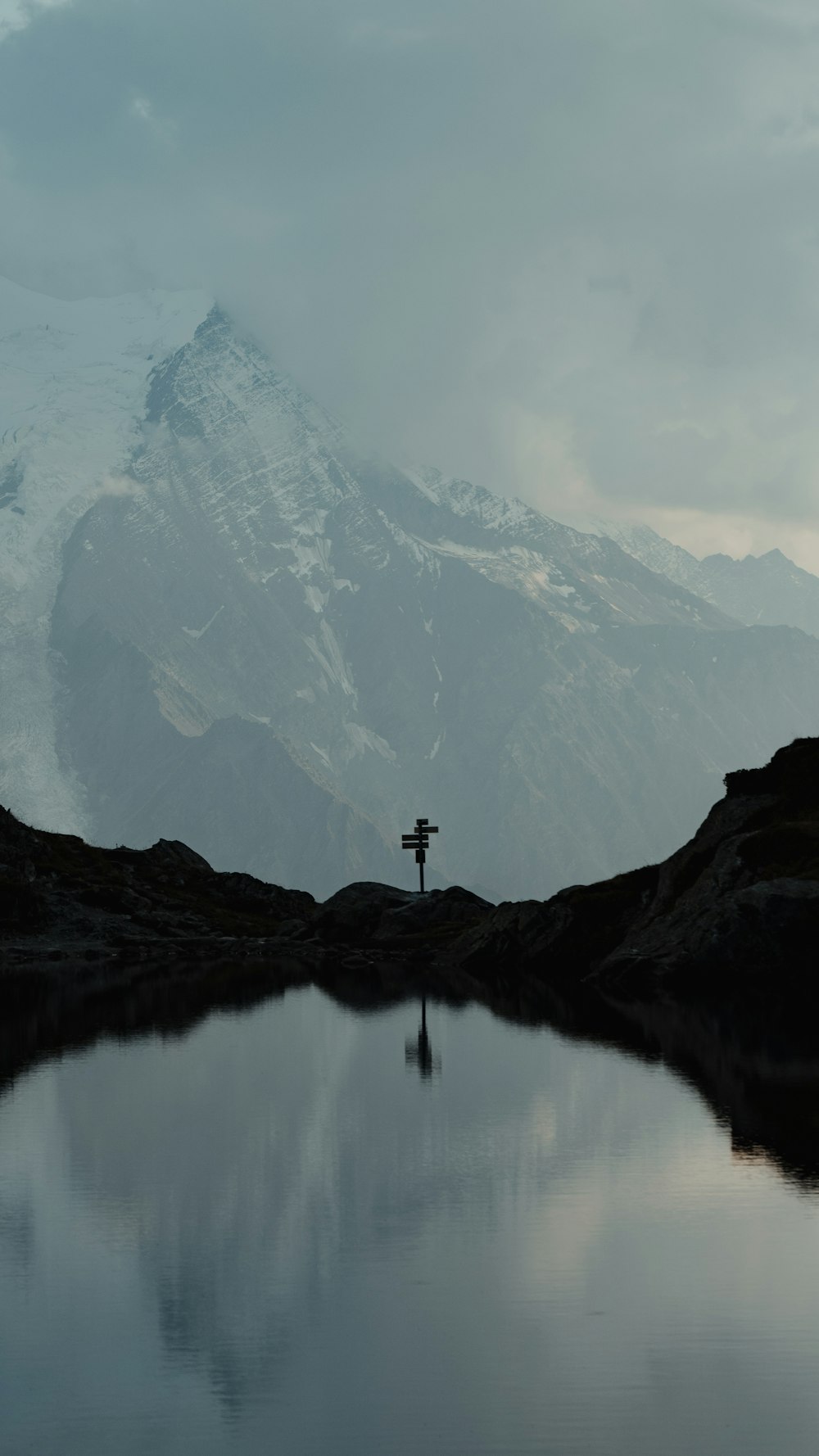 person standing on rock formation near lake during daytime