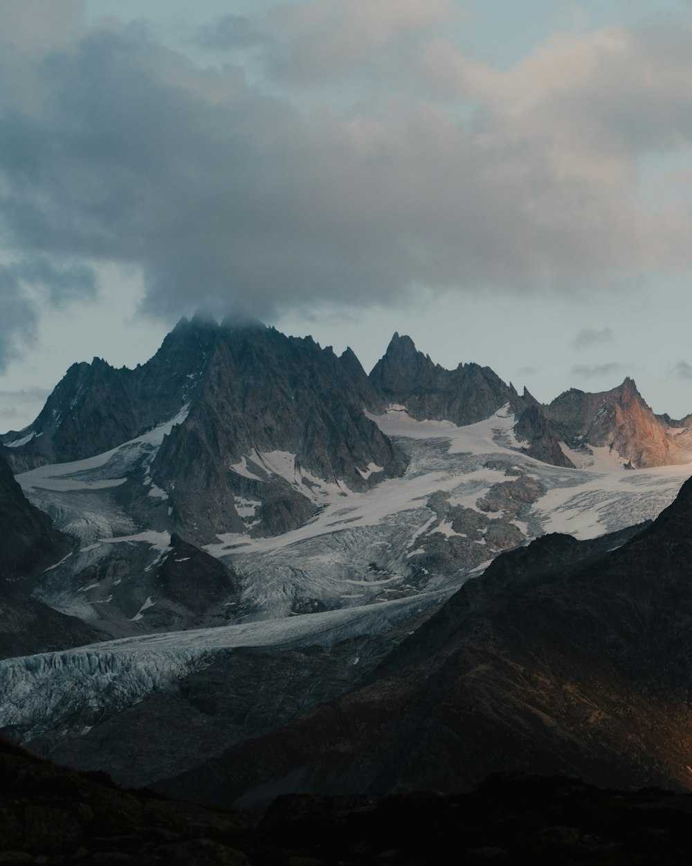 snow covered mountain under cloudy sky during daytime