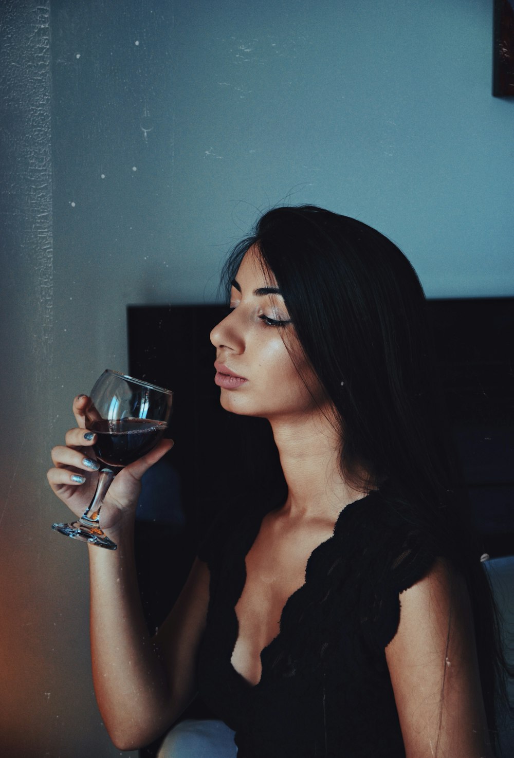 woman holding clear wine glass