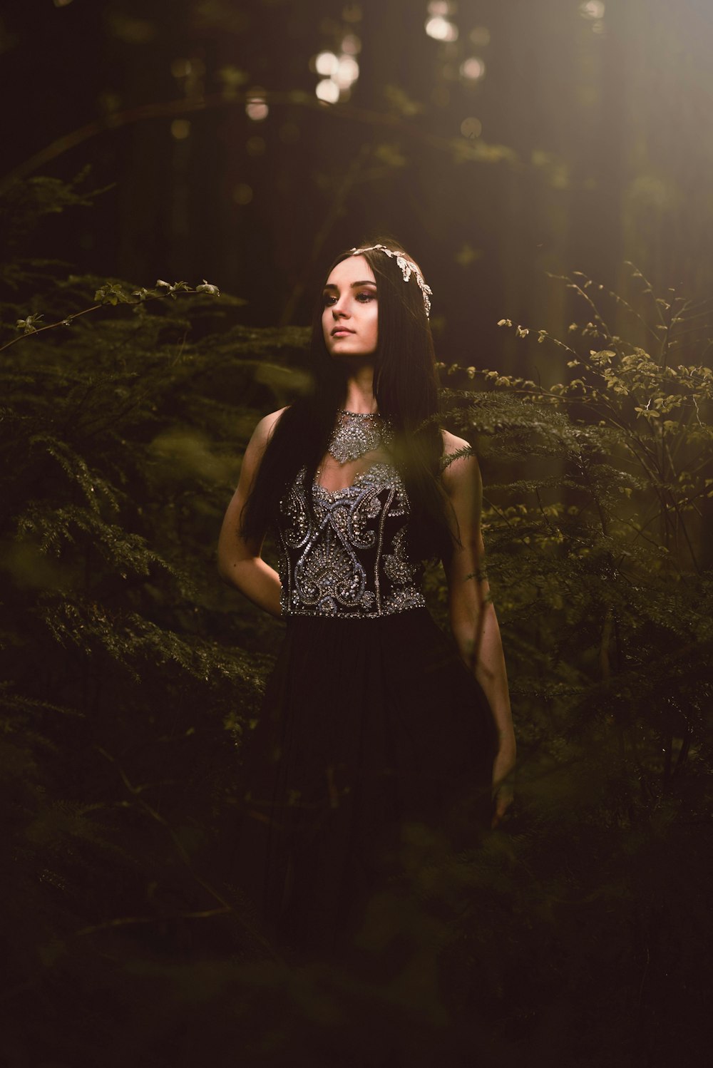 woman in black and white floral sleeveless dress standing on green grass field during daytime