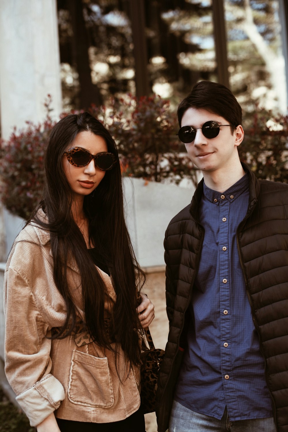 woman in black sunglasses and brown coat