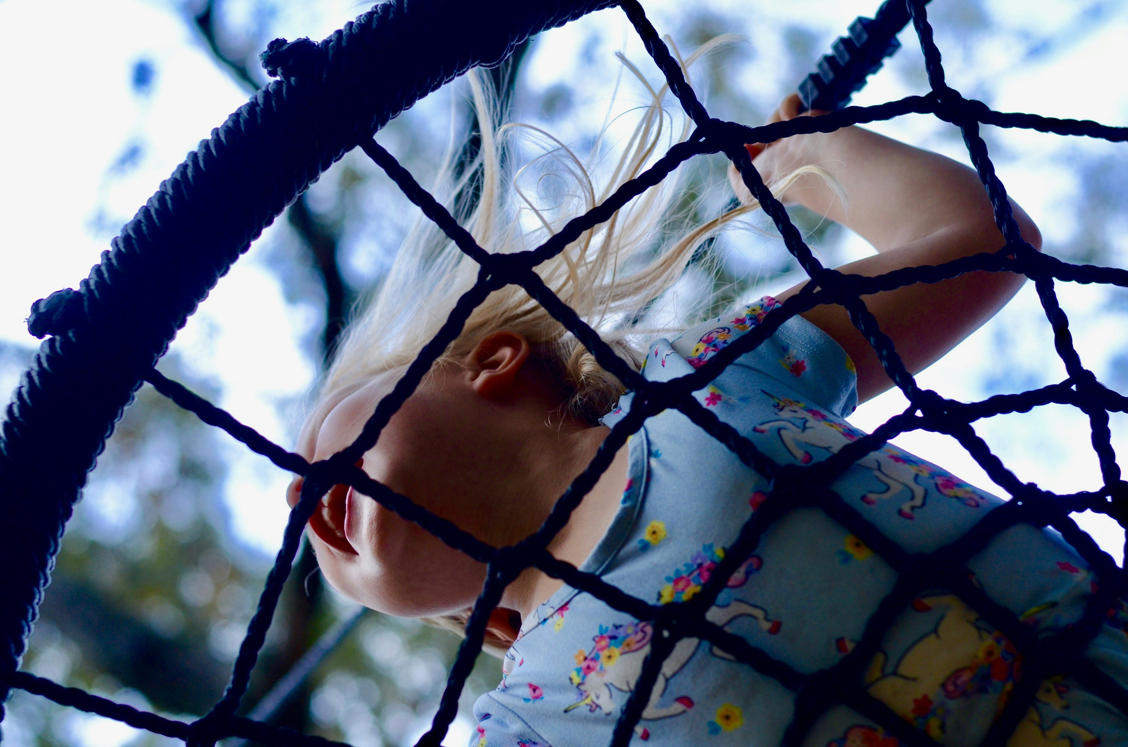 girl in white and blue floral dress on blue and white hammock