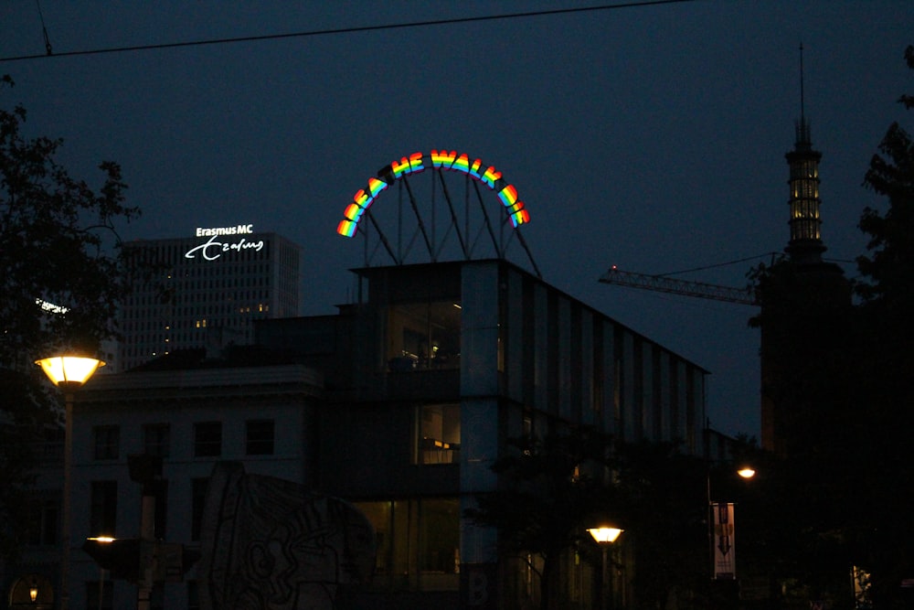 ferris wheel near building during night time