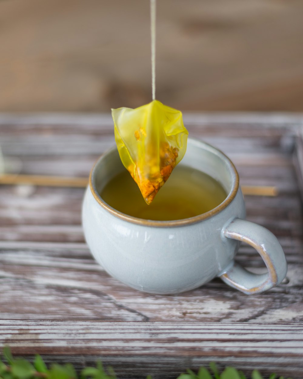 Tasse à thé en céramique blanche avec une feuille jaune dessus