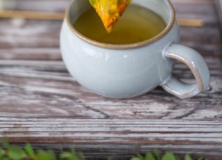 white ceramic teacup with yellow leaf on it