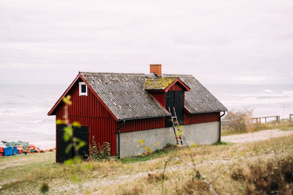 red and brown wooden barn house on green grass field under white clouds during daytime