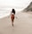 woman in white shirt walking on beach during daytime