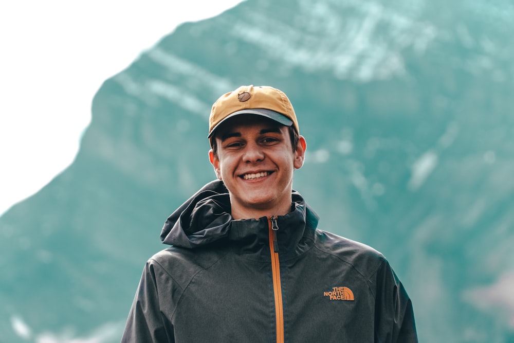 man in black jacket and brown cap