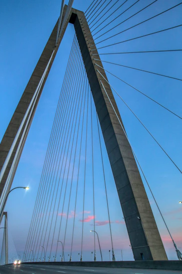 Close-up of cable-stayed bridge cables stretching towards the sky during sunset in Vietnam.