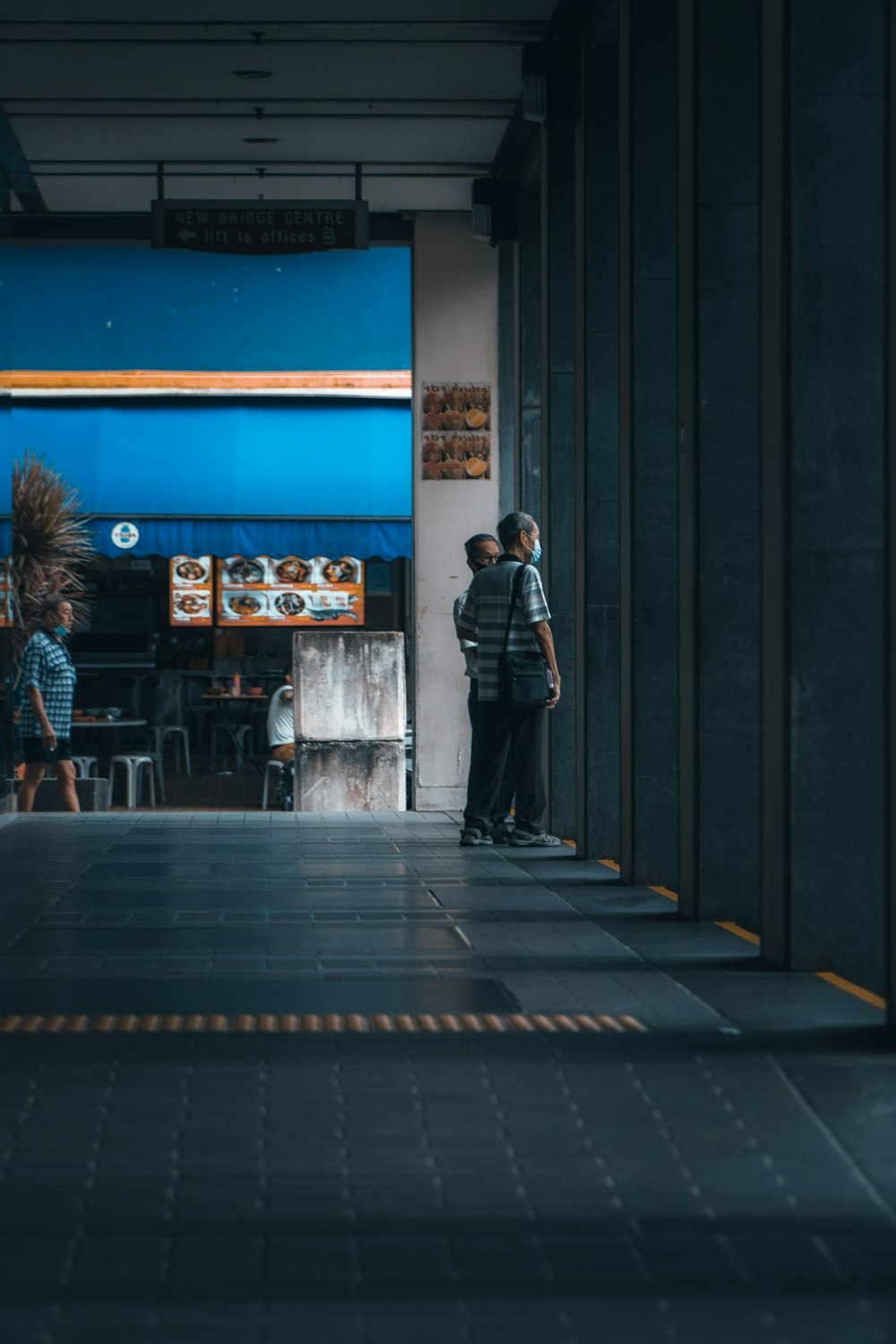 man in black jacket standing near store