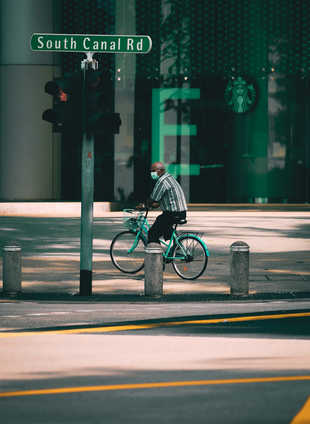 man in black and white stripe shirt riding bicycle on road during daytime