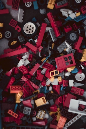 A colorful shopping cart filled with various brick toys and accessories.