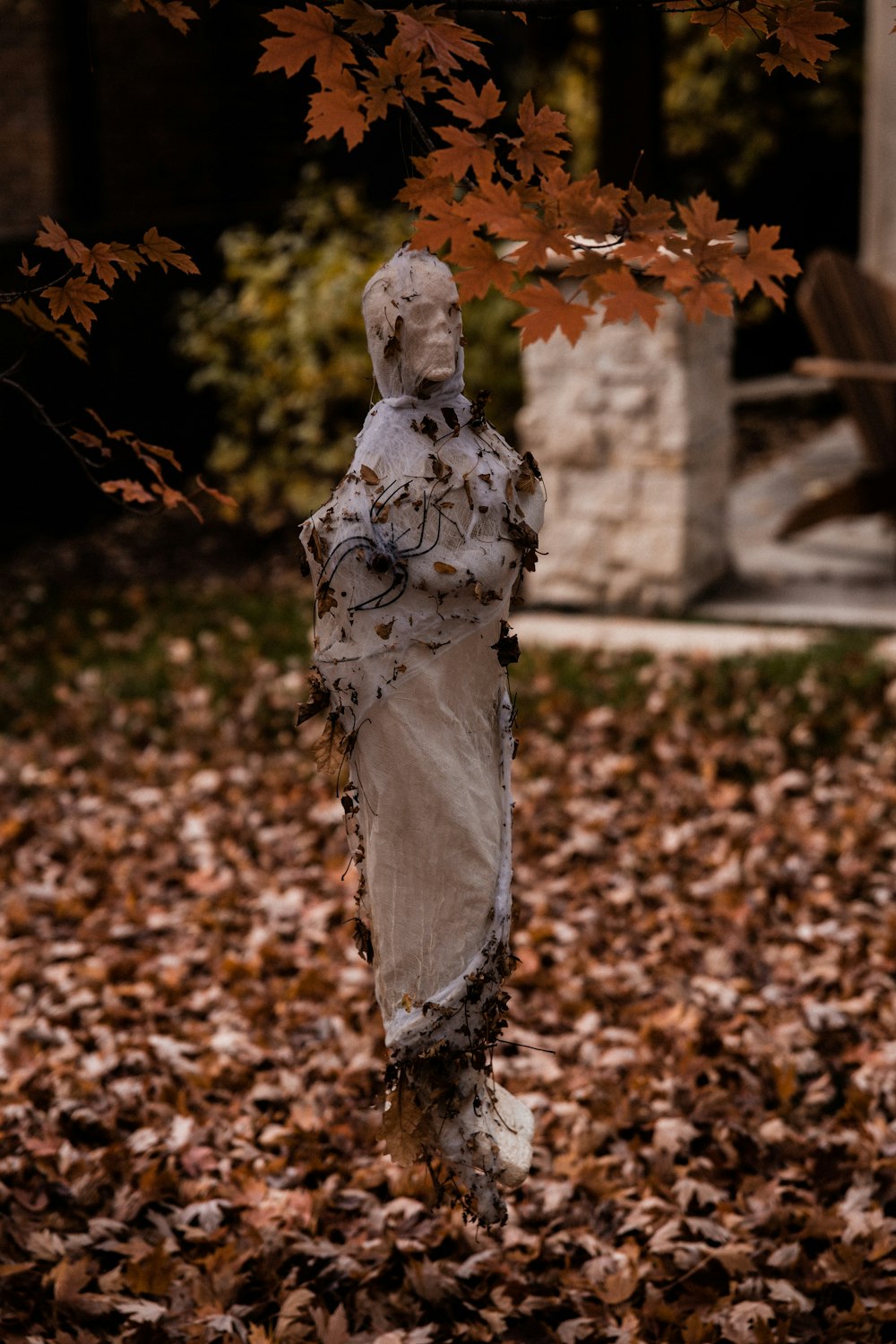 Frau in weißem Kleid mit braunen Blättern