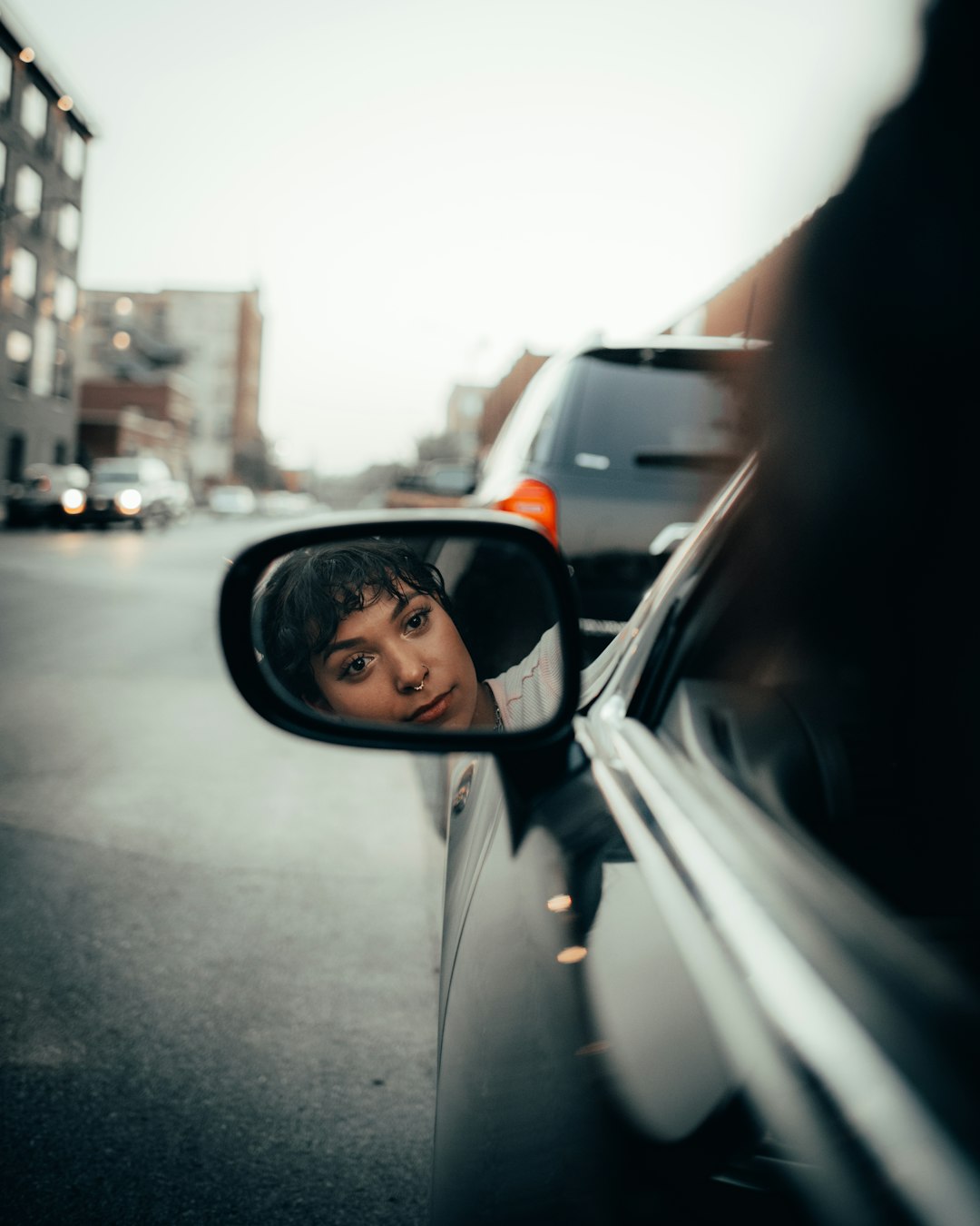 car side mirror showing cars on road during daytime