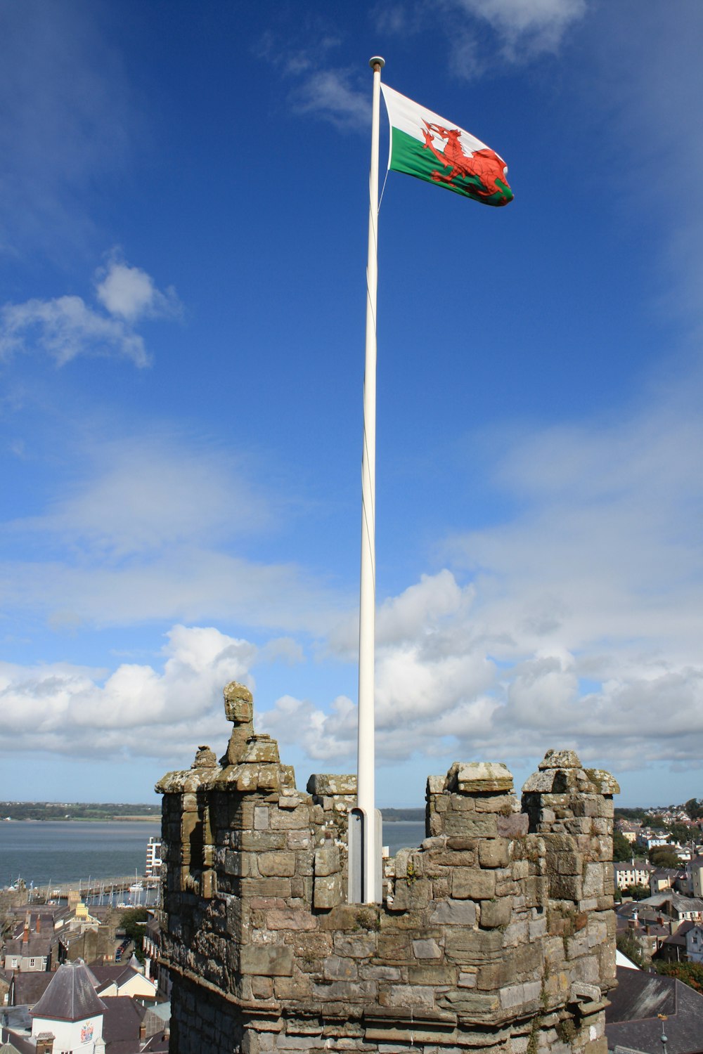 Weiße und blaue Flagge auf grauer Felsformation in der Nähe von Gewässern tagsüber