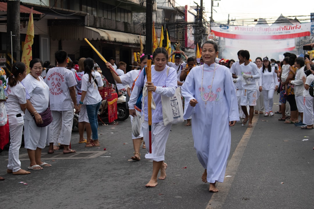 people in white robe standing on gray concrete floor during daytime, Vegetarian festival in Phuket.<p></figure>The Chinese community