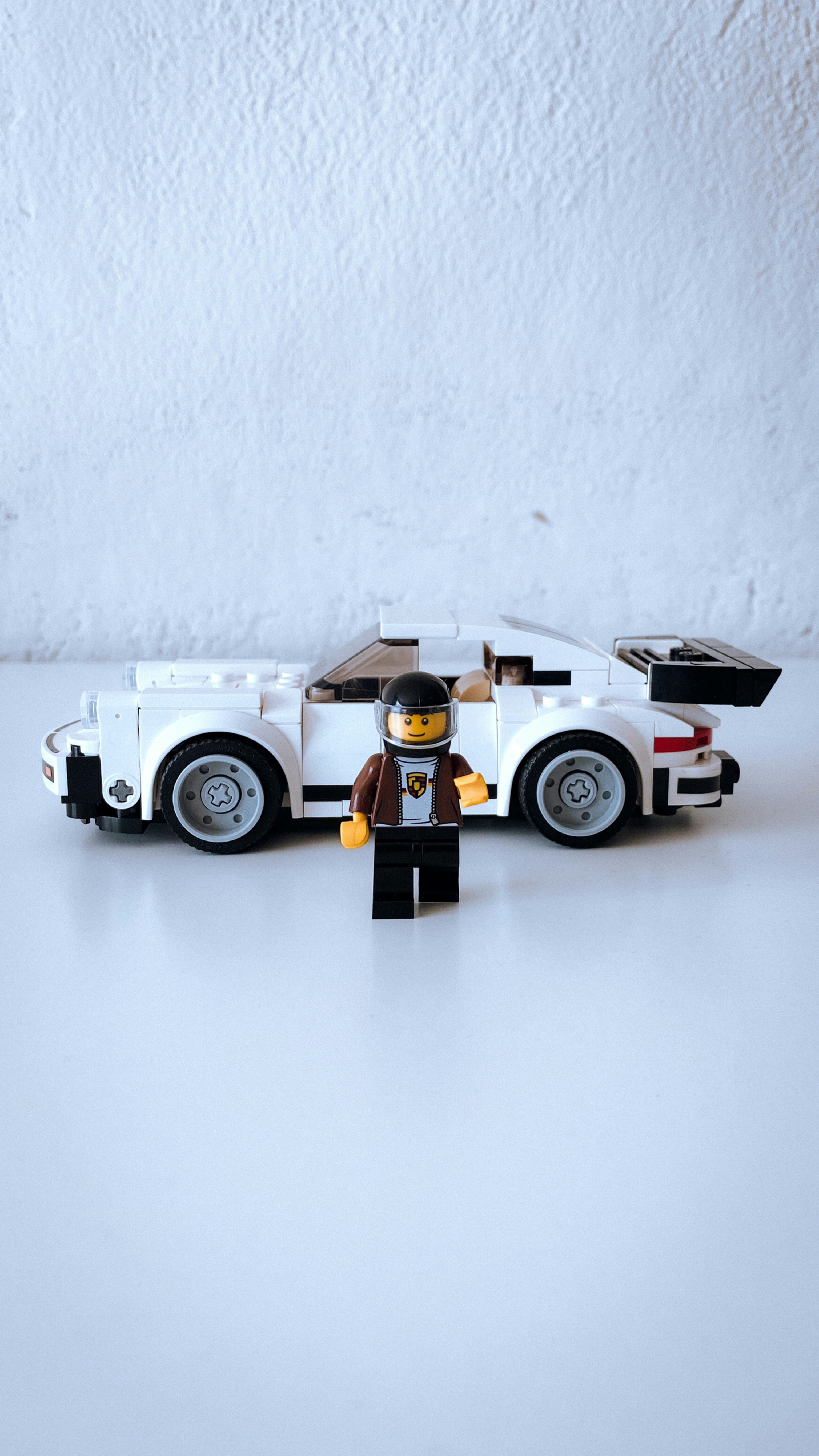 A dynamic LEGO race car speeding on a track made of bricks.