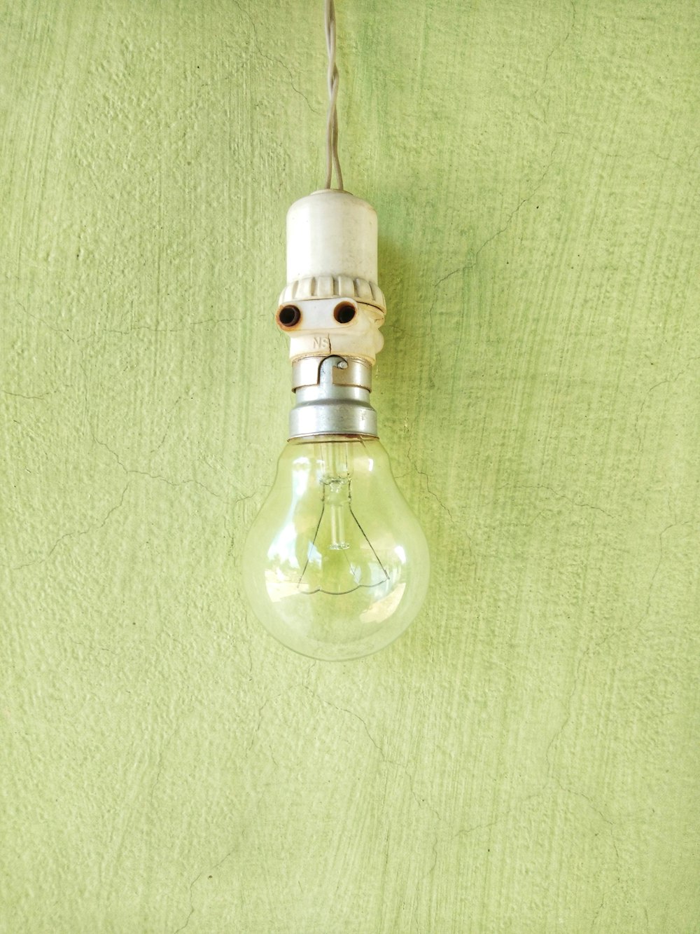 clear glass light bulb on green textile