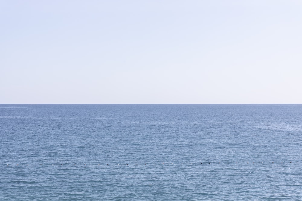 body of water under white sky during daytime