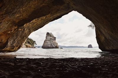 brown rock formation on sea shore during daytime coast zoom background