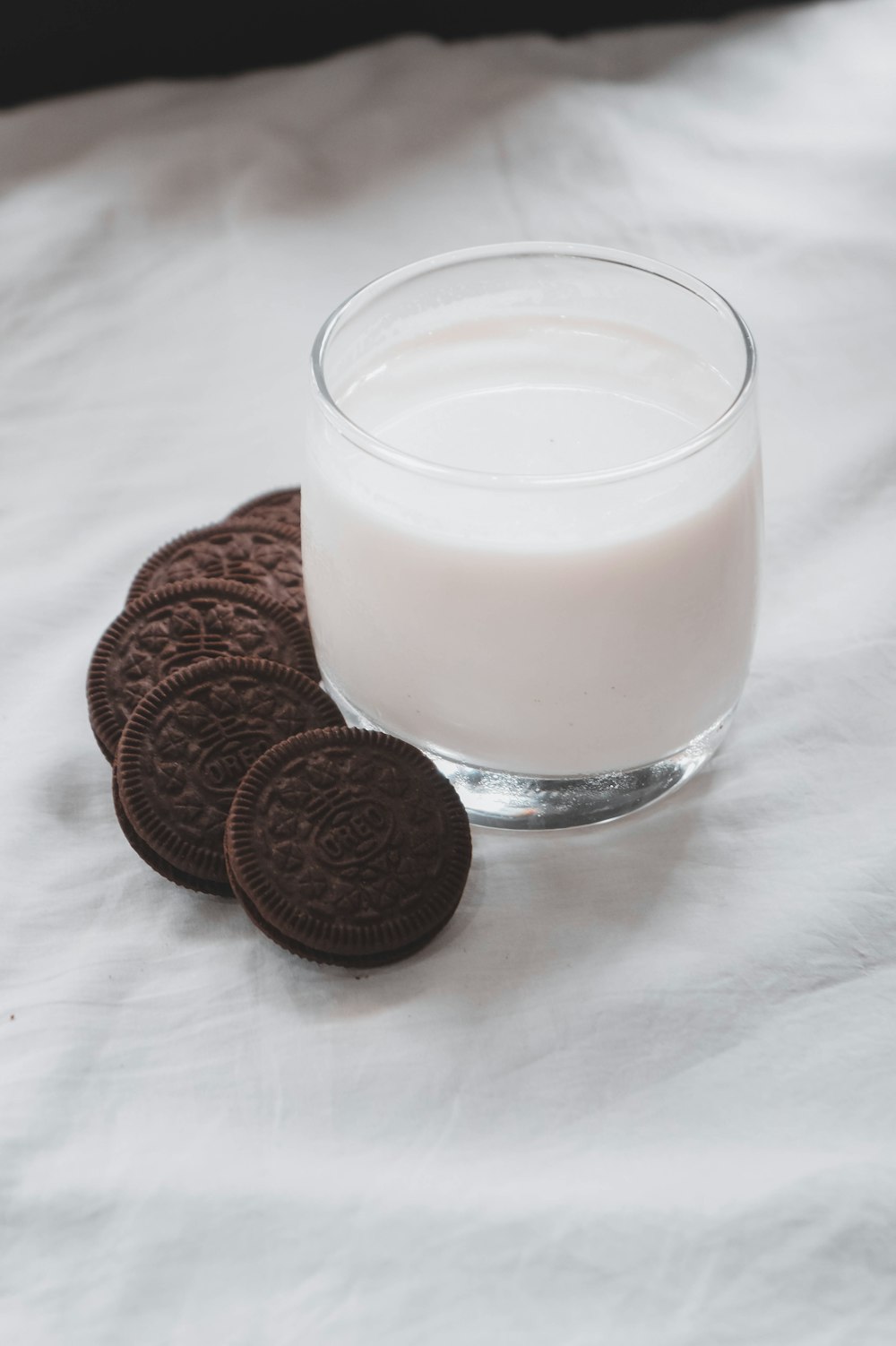 clear drinking glass with milk and chocolate cookies