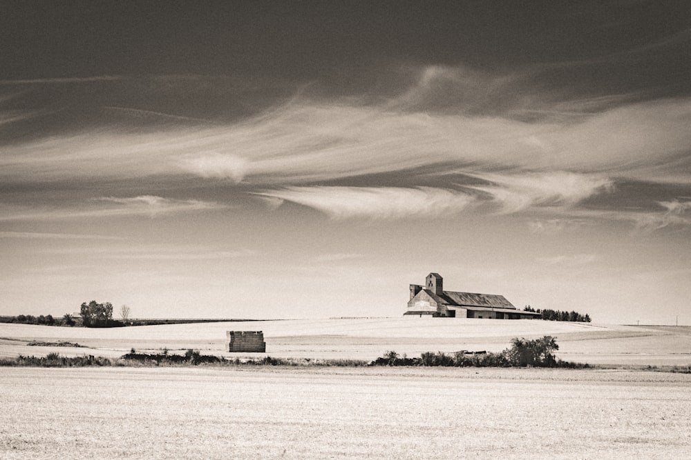 grayscale photo of house on snow covered field