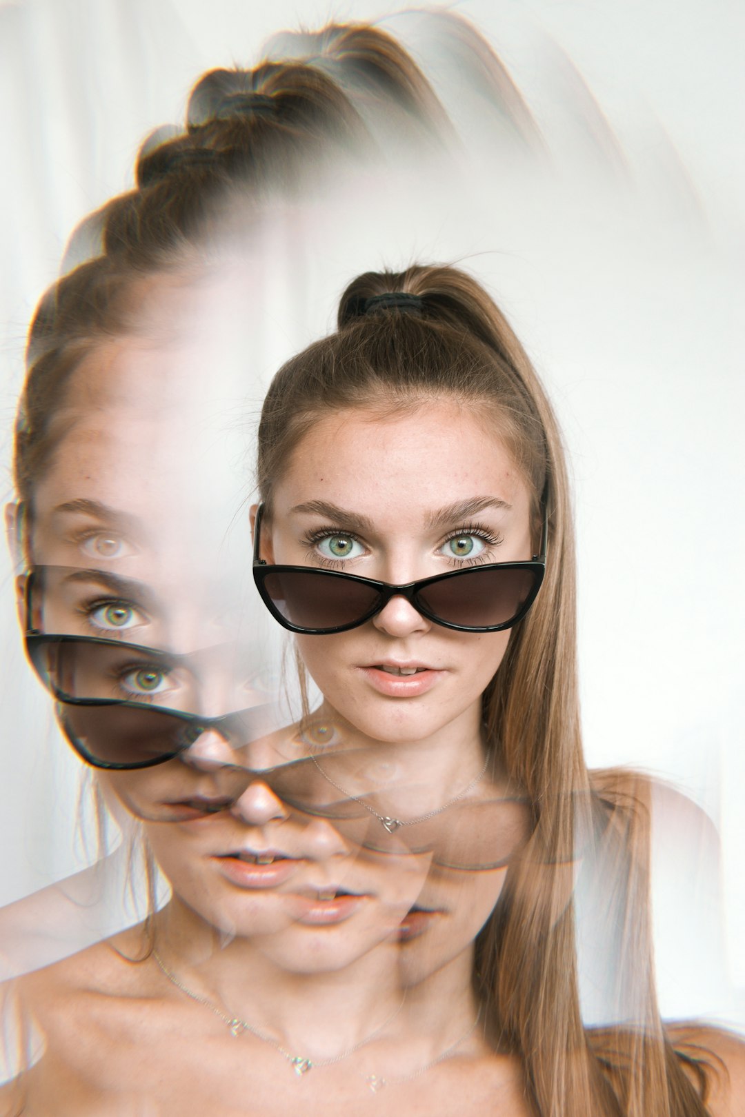 woman in black sunglasses holding womans face