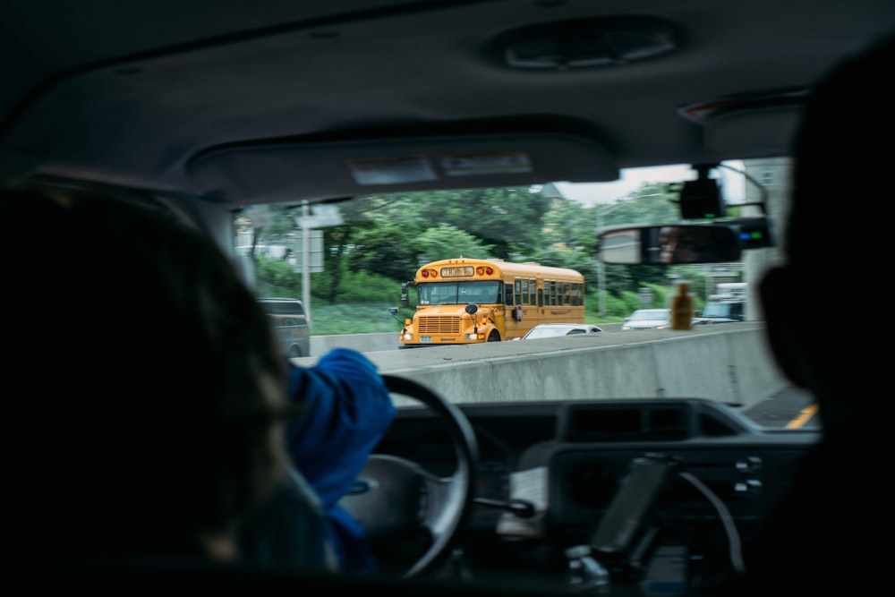 people riding on yellow school bus during daytime