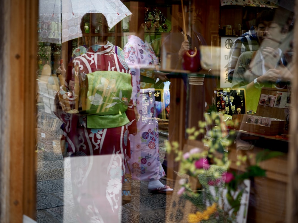 woman in red and white kimono standing near brown wooden cabinet