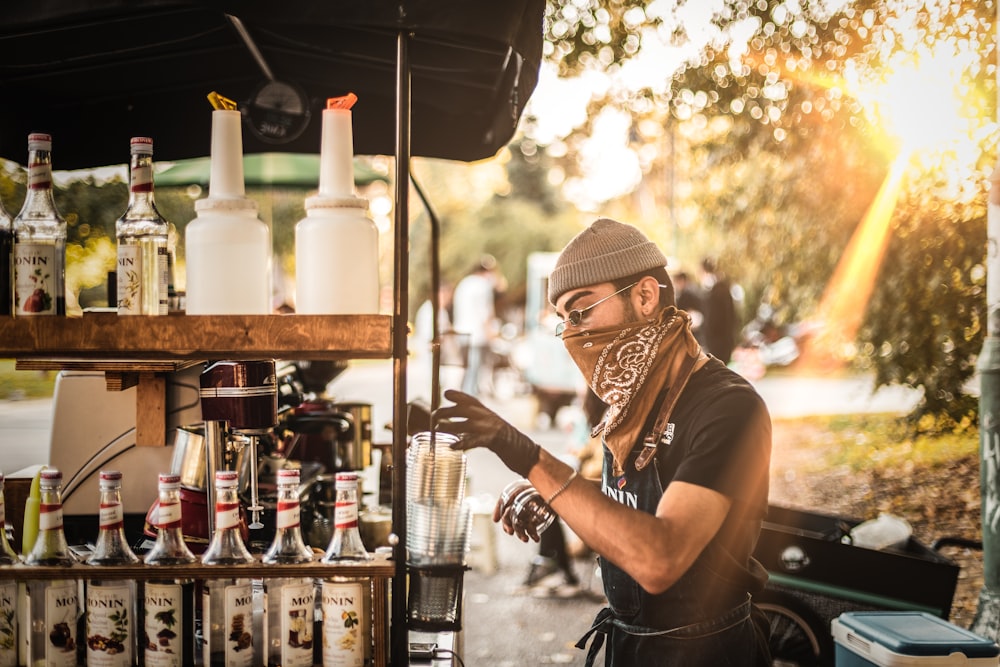 woman in black tank top pouring water on clear drinking glass