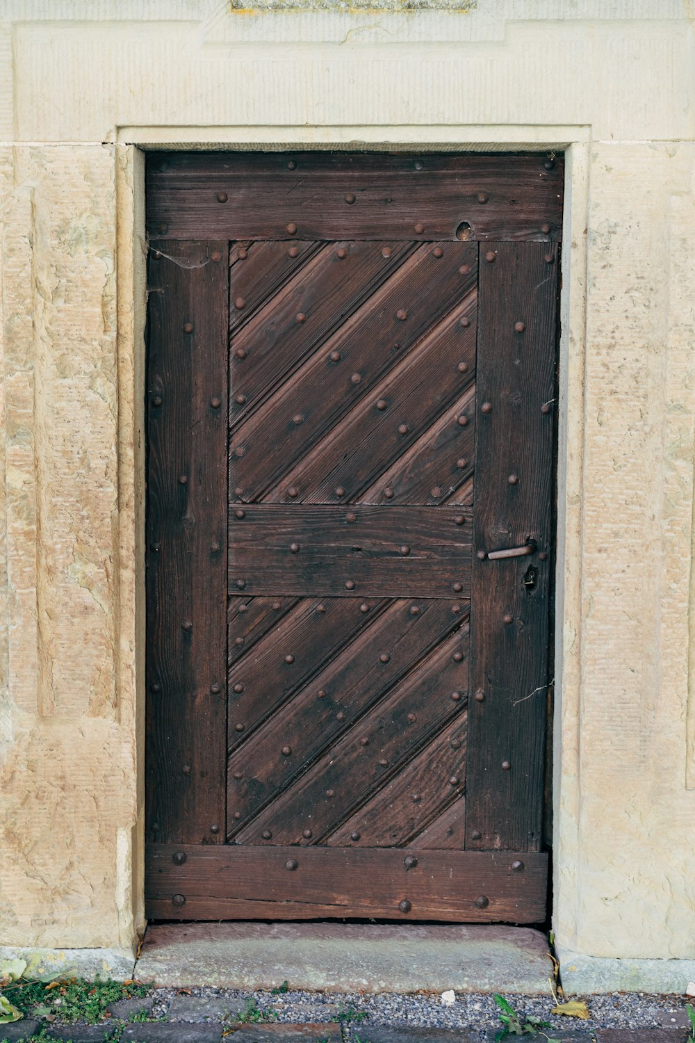 puerta de madera marrón sobre pared de hormigón blanco