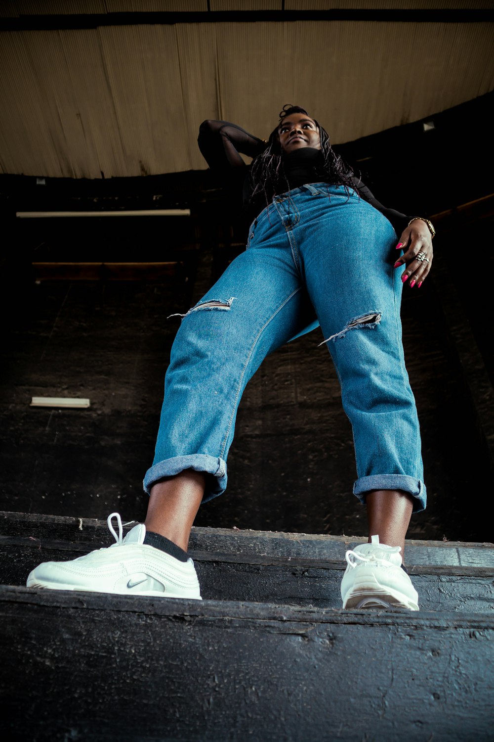 woman in blue denim jeans and white nike sneakers