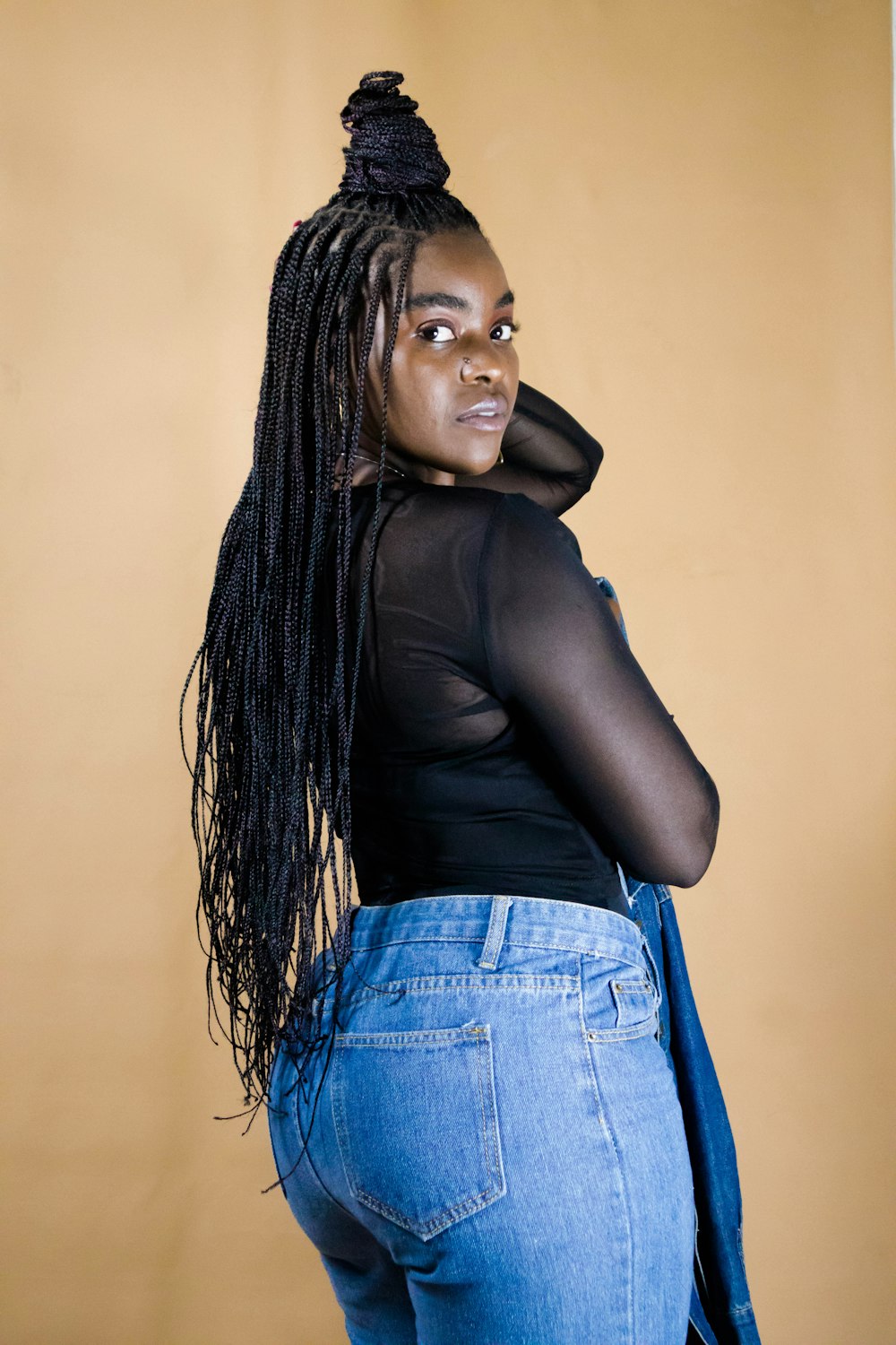 a woman with long hair wearing jeans and a black top