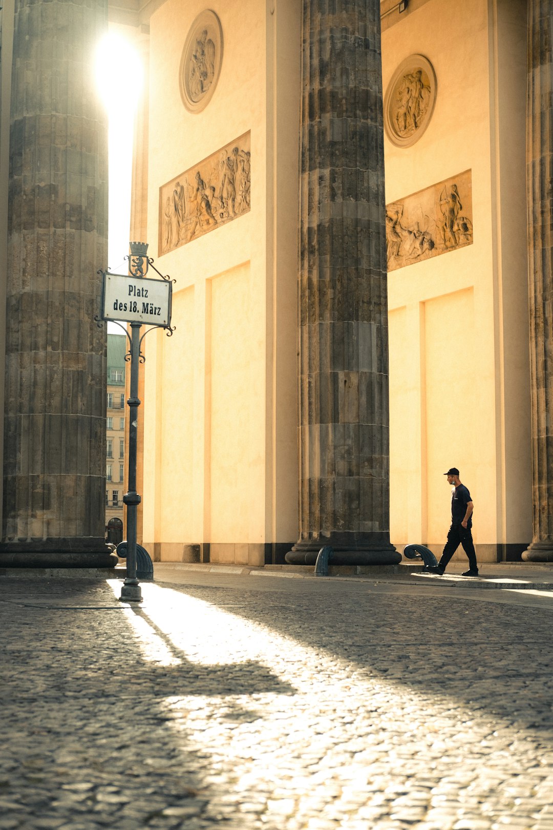 man in black jacket walking on sidewalk during daytime