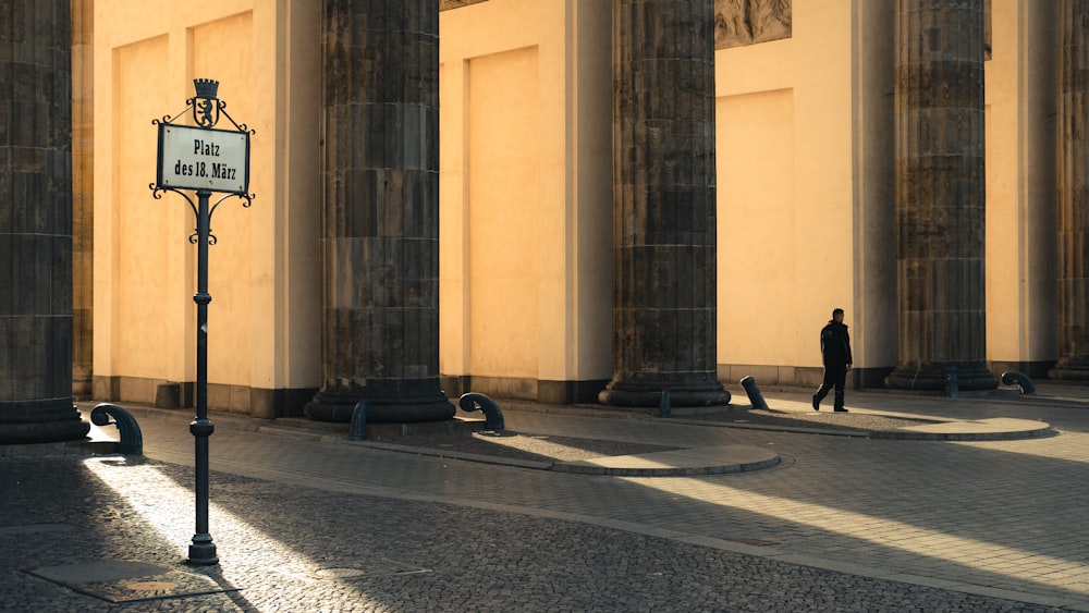 man in black jacket walking on sidewalk during daytime