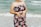 woman in black red and white floral tube dress standing on beach during daytime