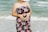 woman in black red and white floral tube dress standing on beach during daytime